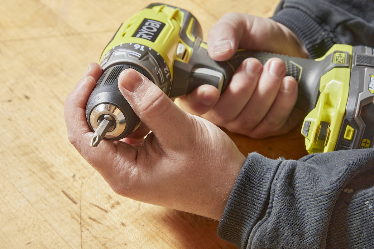 Handyperson inserts a new bit into a cordless drill.