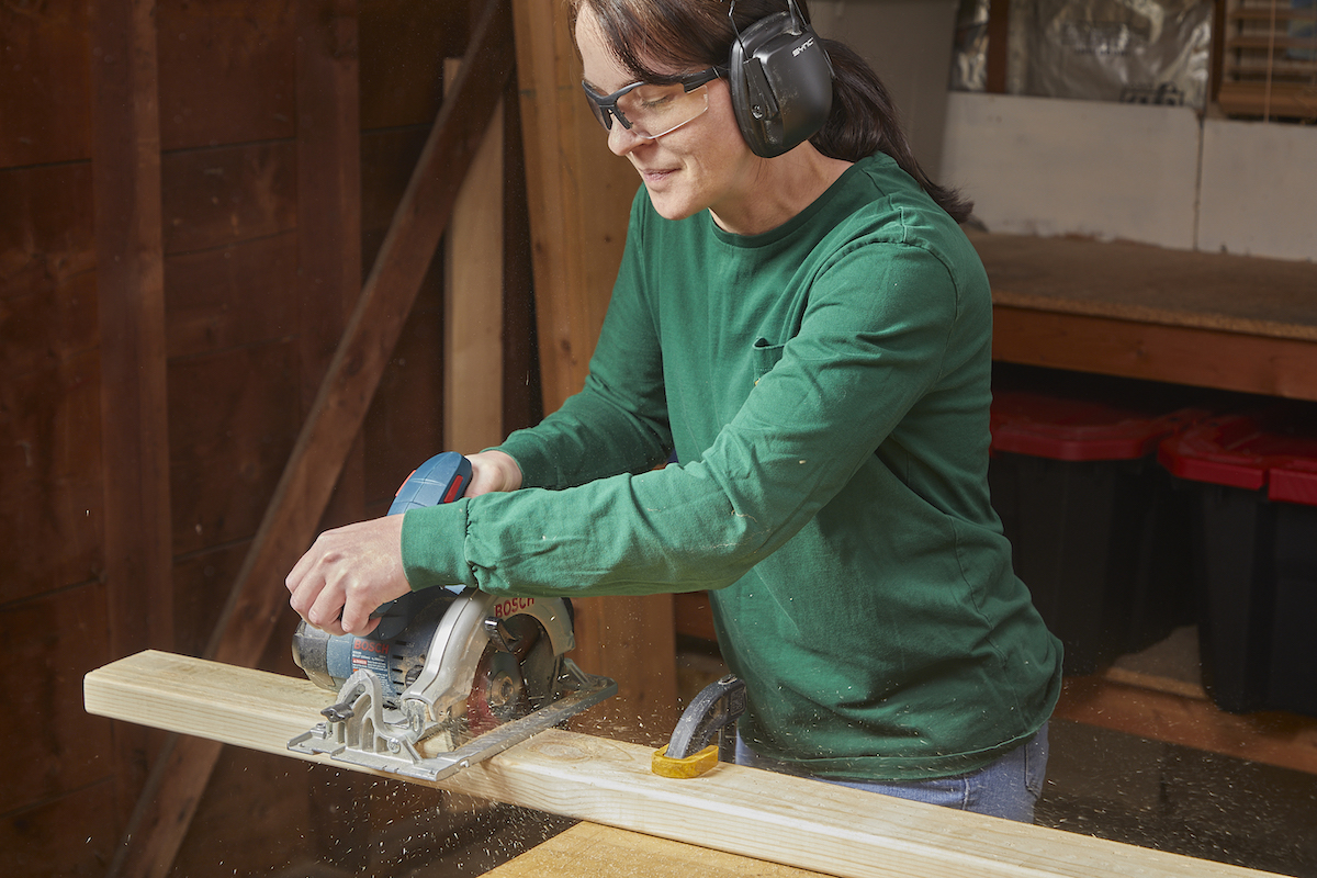 Woman making a cross cut with a circular saw.