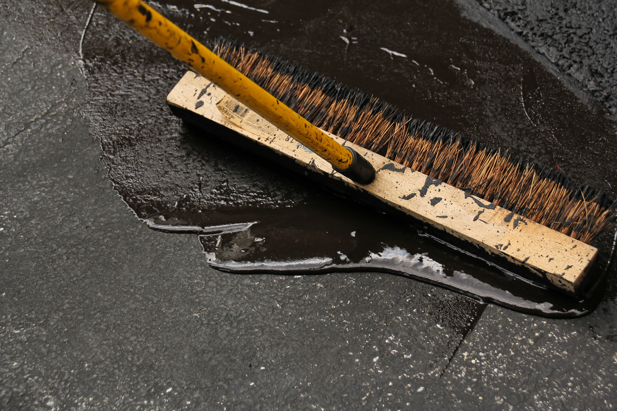 Asphalt driveway sealing with flat brush