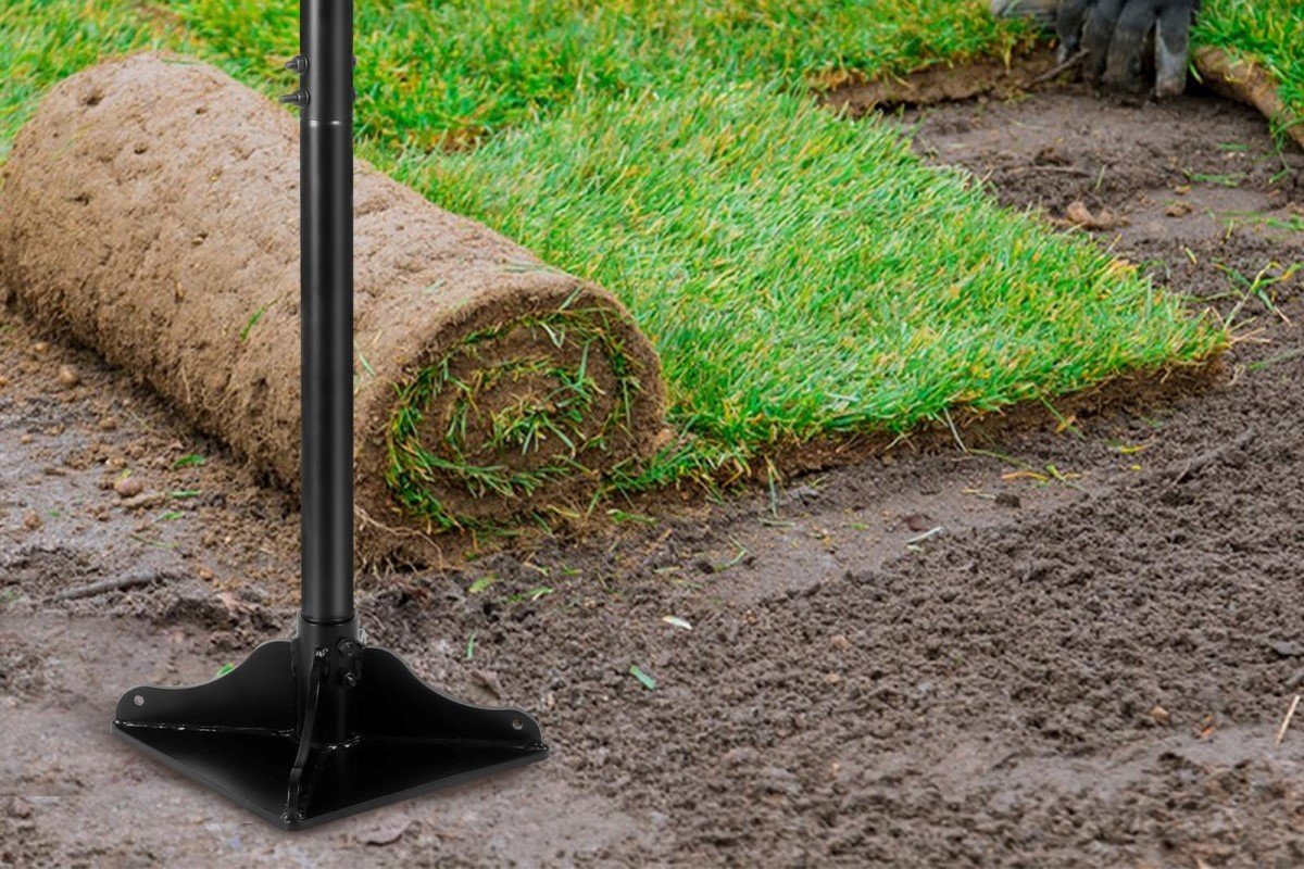 A tamper used to cover hole with sod in the background.