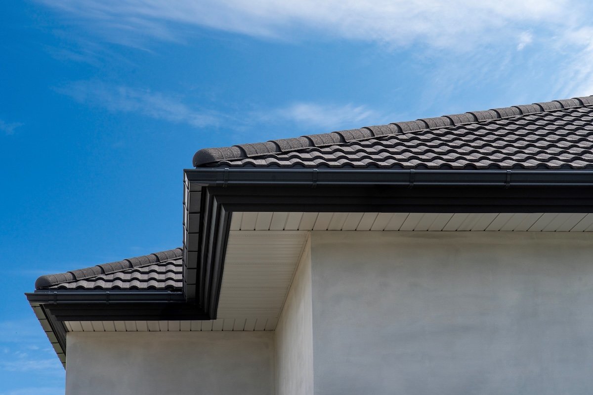 Hip roof eaves with soffit panel, metal roof tile and gutter