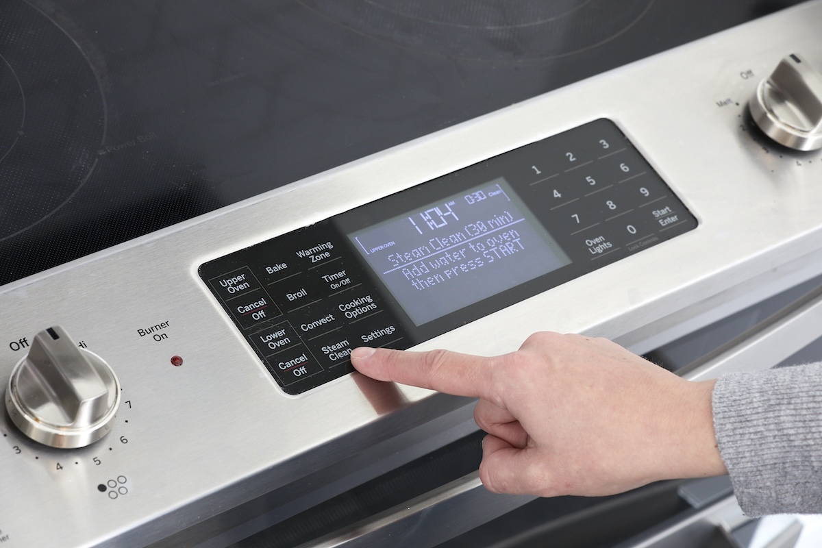 A stainless steel oven with a steam cleaning setting.