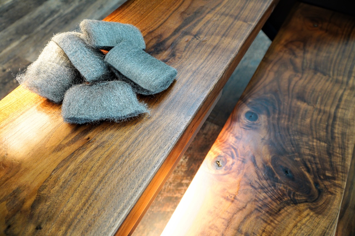 Steel wool is used to sand the finish on black walnut stairs.