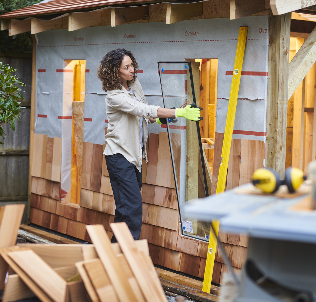 woman glazing her part built shed