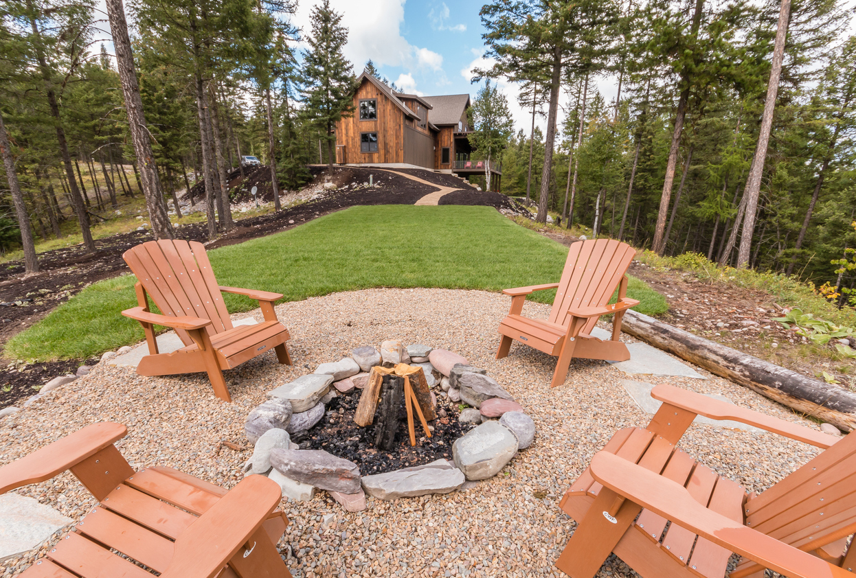 Circular fire pit area in back of home in the forest