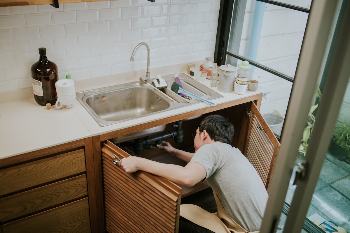 A man installs a drop in sink in a modern kitchen.
