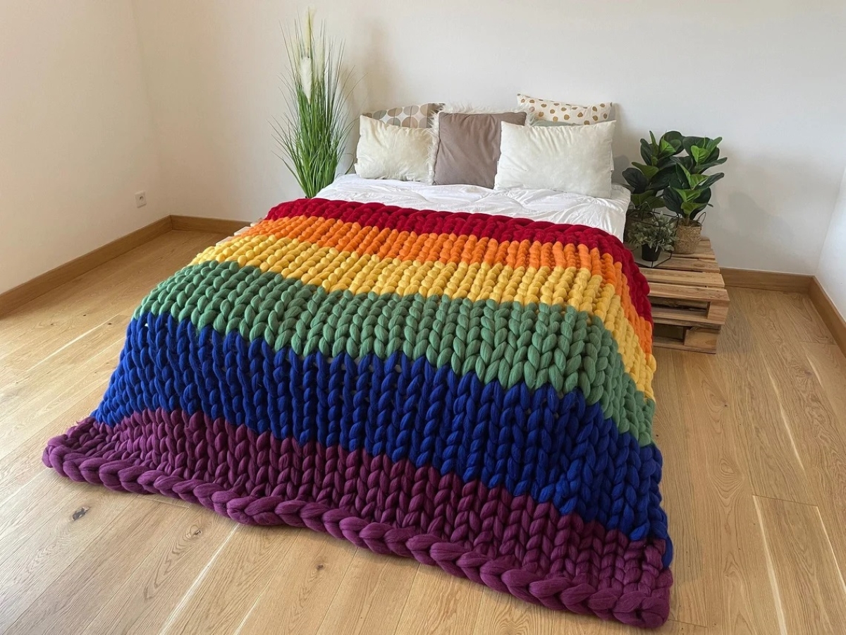 Rainbow wool blanket on bed