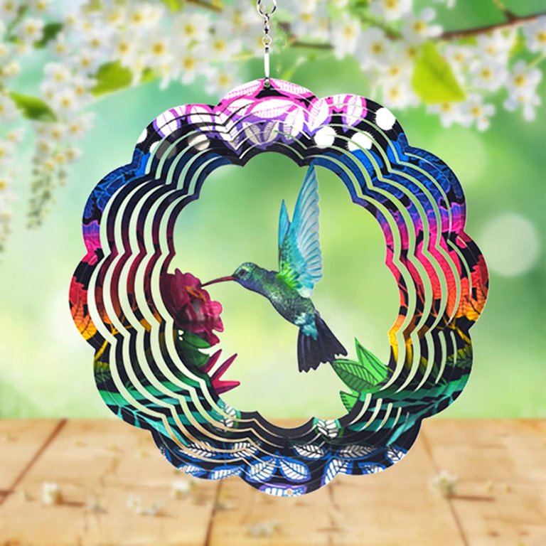The Uoudio Stainless Steel 3D Hummingbird Wind Spinner hanging from a blooming branch