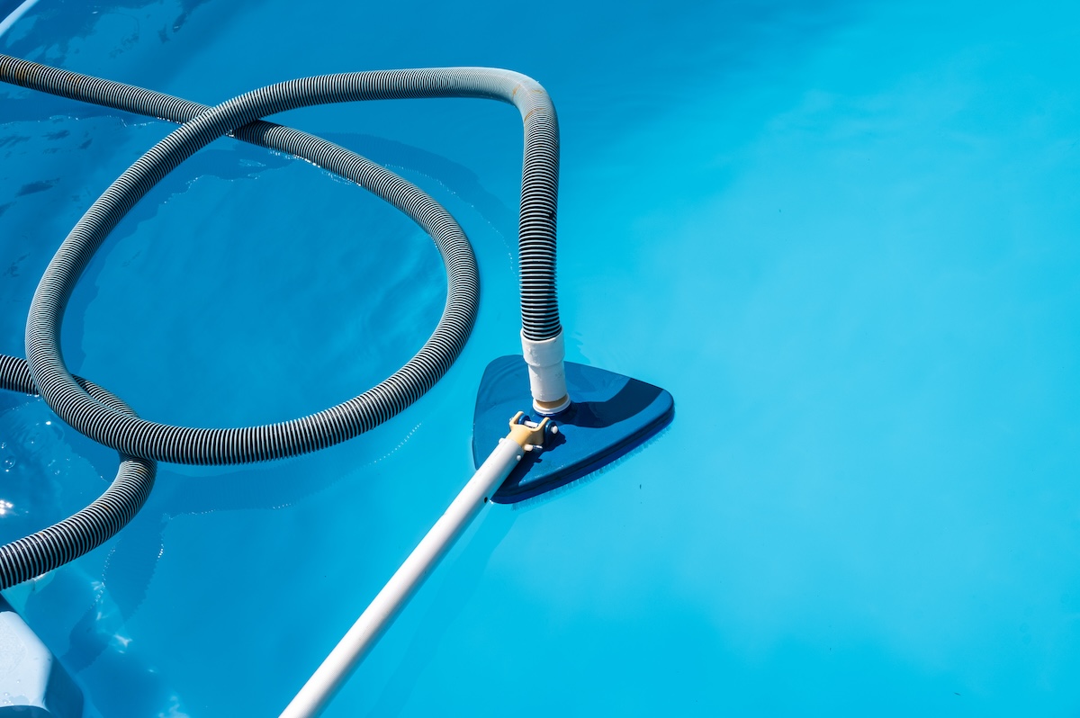 A triangular pool vacuum submerged in a pool.