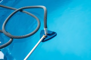 A triangular pool vacuum submerged in a pool.