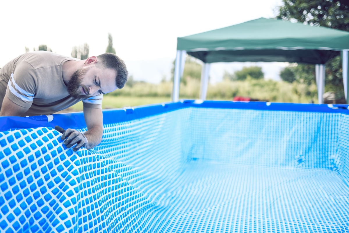 A repairperson applies a new liner to an above-ground pool.