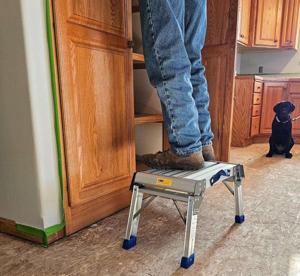 A person on the MaxWorks Foldable Aluminum Platform Step Stool