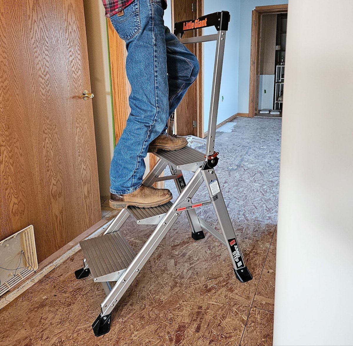 a person on the second step of the Little Giant type of step stools