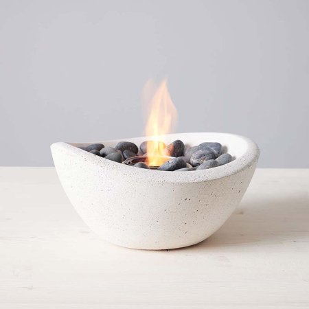  The TerraFlame Wave Tabletop Fire Bowl with a small flame coming from it.
