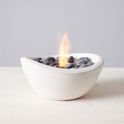 The TerraFlame Wave Tabletop Fire Bowl with a small flame coming from it.