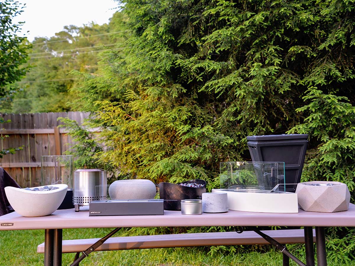 A group of the best tabletop fire pits on a picnic table before testing.