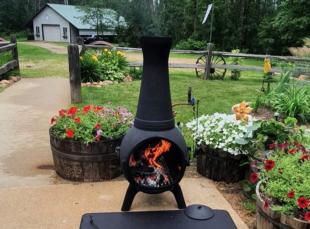 The best chiminea option set up on a cement pad near large planters on a ranch