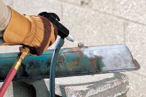 A person using the best sandblaster option to remove rust from metal