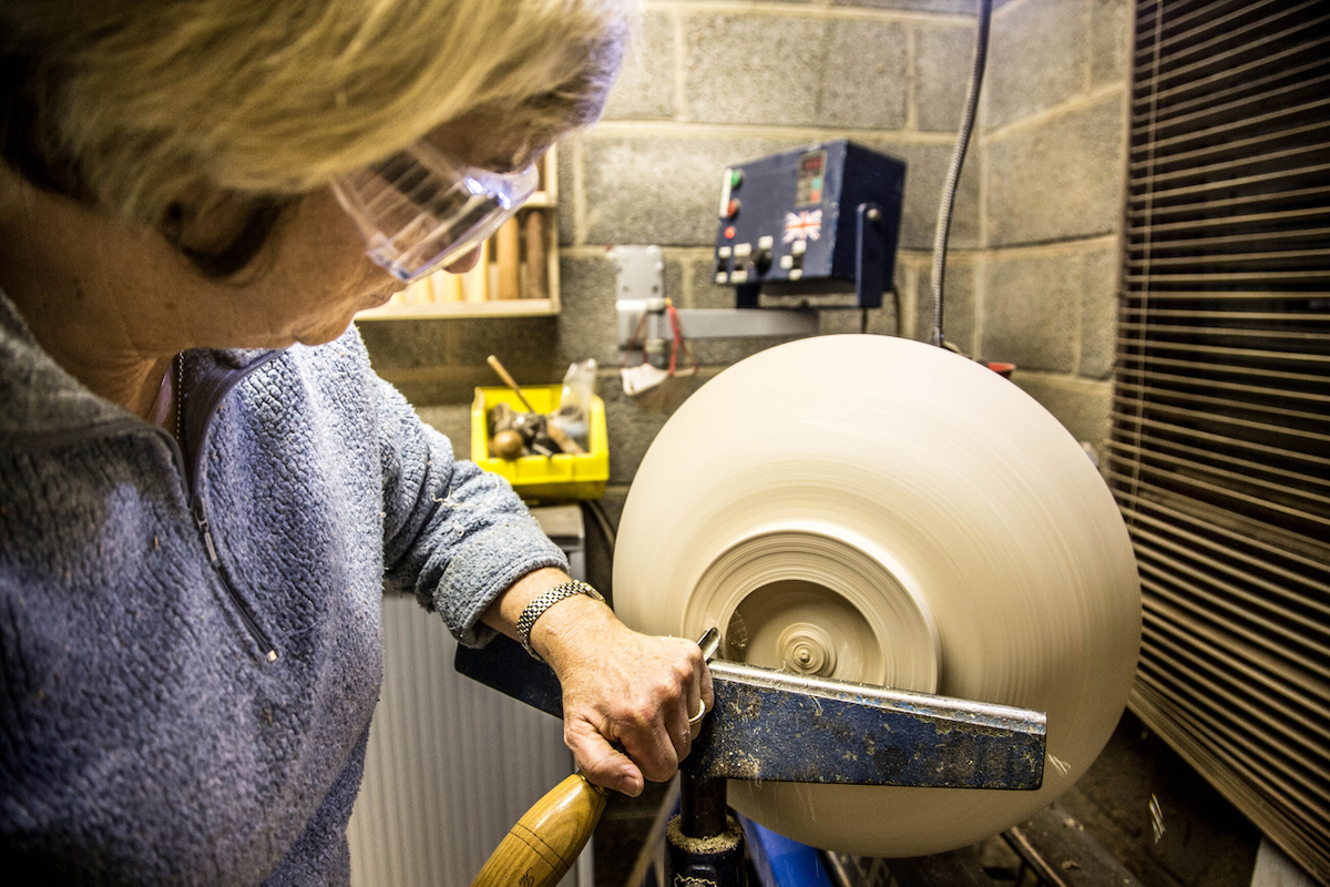 woman turning large bowl on lathe - woodturning for beginners - new year, new skill
