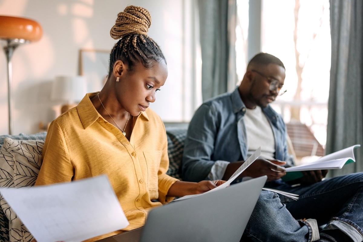 A couple reading their HOA paperwork at home.