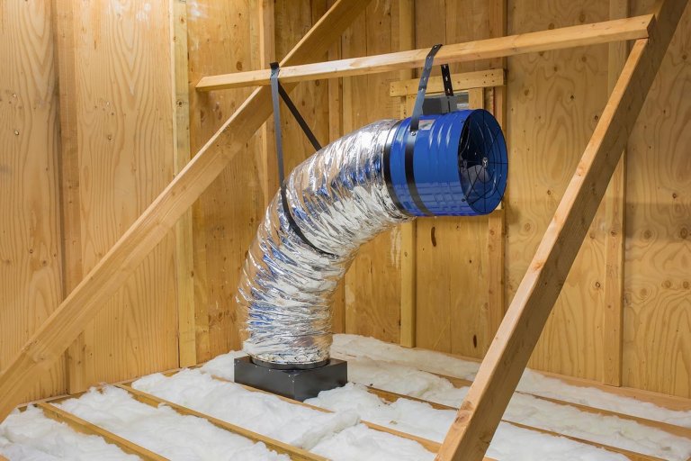 An attic fan installed in a clean home attic space.