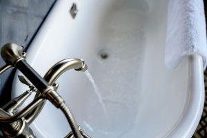Looking down on the best freestanding tub option as it fills with water from an attached faucet