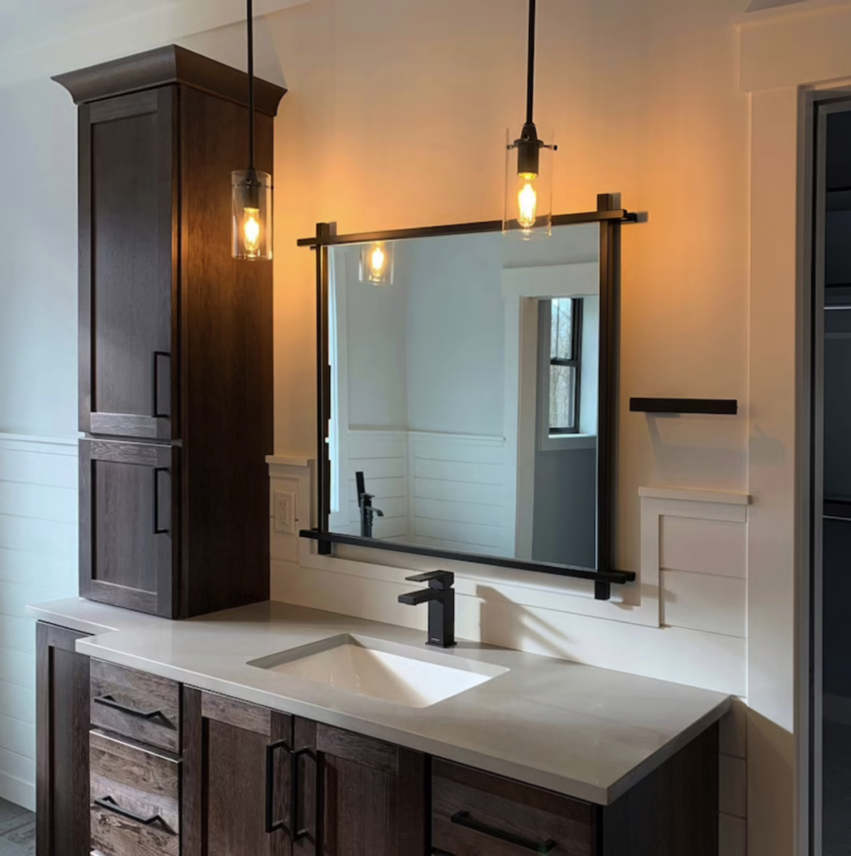 Large bathroom mirror with industrial-style steel frame that crosses at the corners.