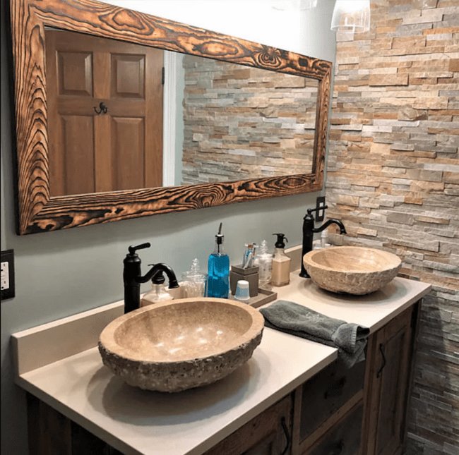 Wide rectangular bathroom mirror framed by dark reclaimed wood with distressed wood grain