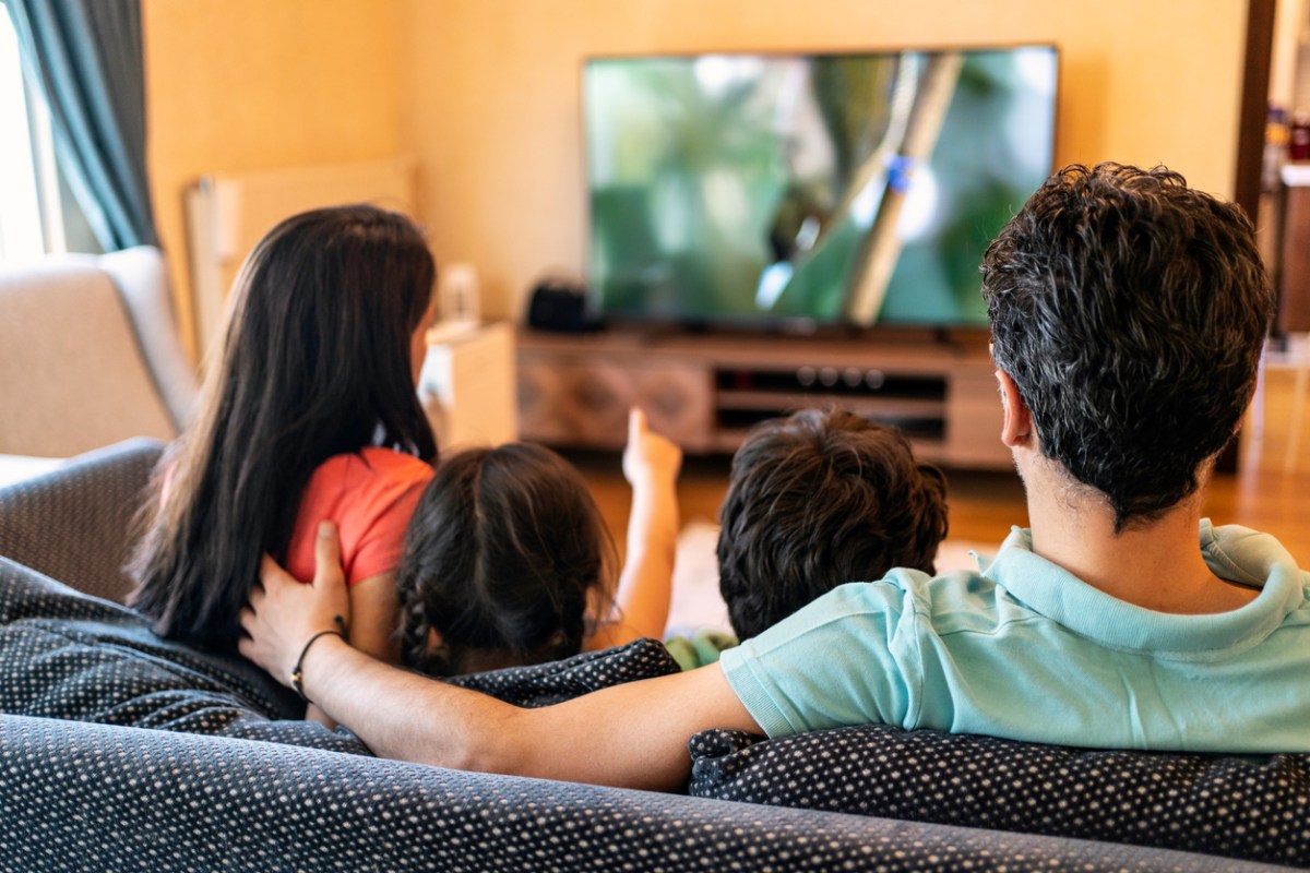 Family watching a medium-size television on a living room couch
