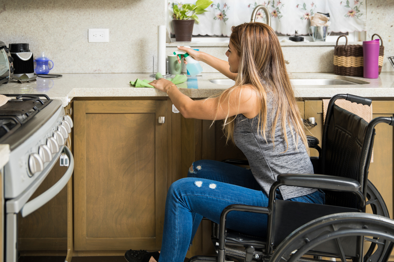 november must dos woman in wheelchair cleaning kitchen
