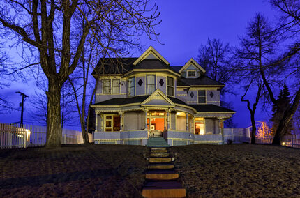 Haunted house styles Victorian house against purple sky