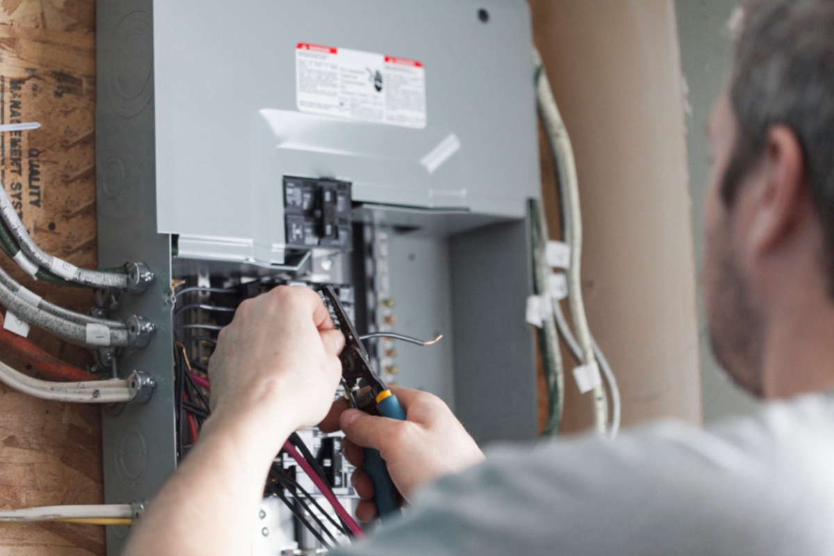 12 Ways to Make an Old Home More Energy Efficient - man working on electrical panel