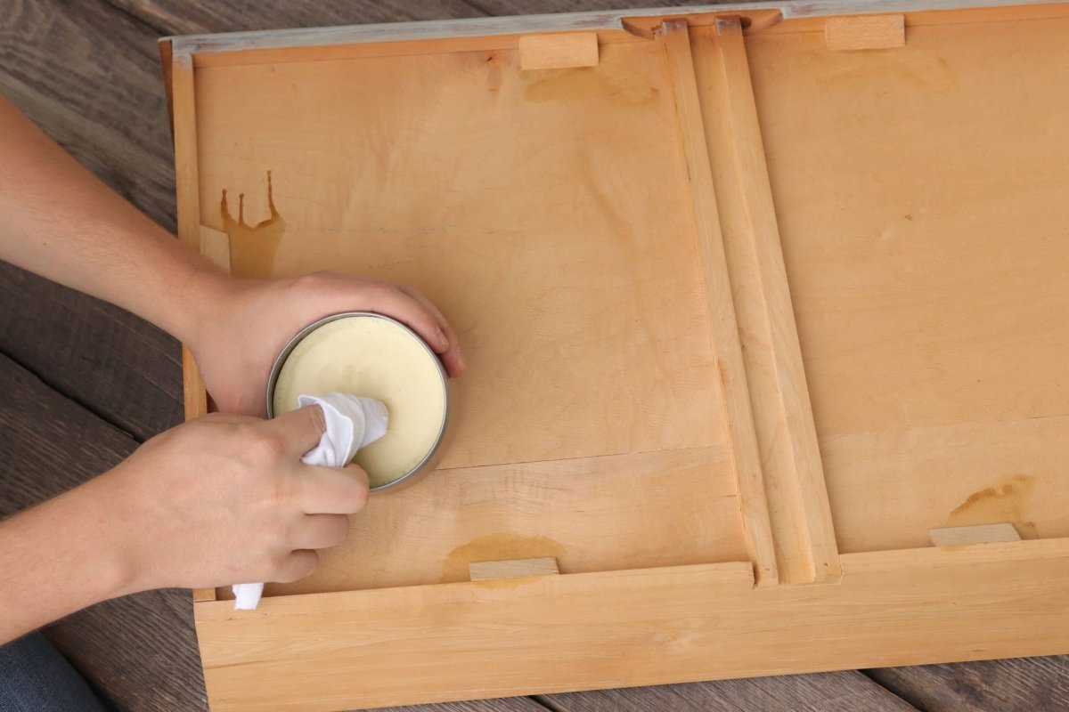 Person applying paraffin to fix drawer slides.