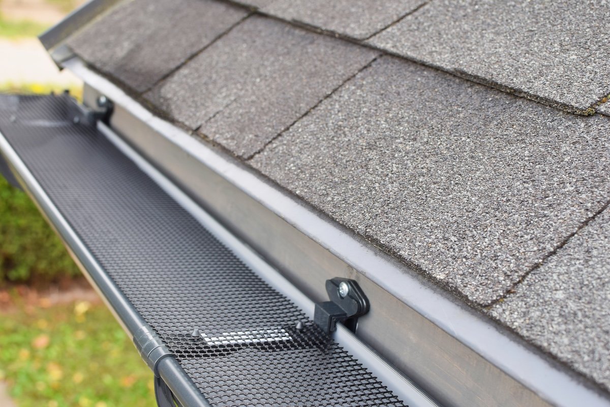 A screened guttered guard on exterior gutters of a residential building.