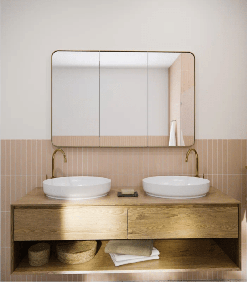 Large recessed medicine cabinet with metal frame, over bathroom vanity with two bowl sinks.