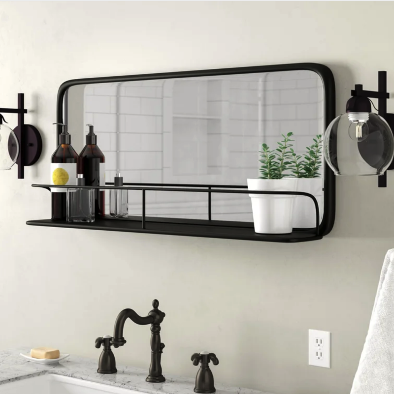 Horizontal bathroom mirror with metal frame and a shelf in front of the mirror.