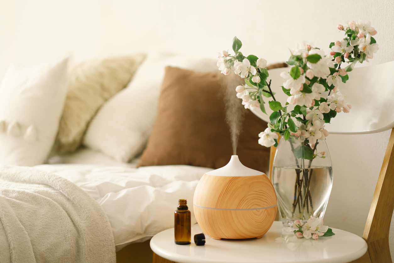 Diffuser and a flower vase filled with water on a bedside table