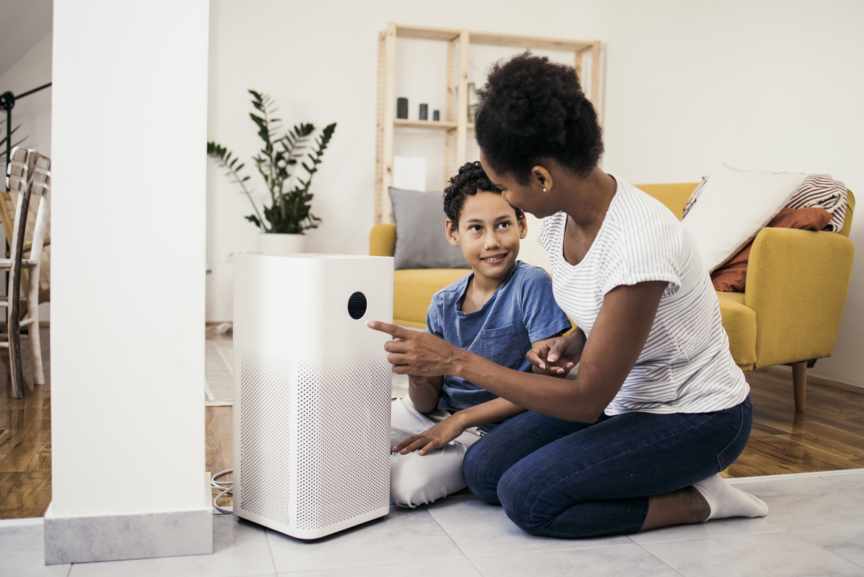 Woman and son setting up an air filter.