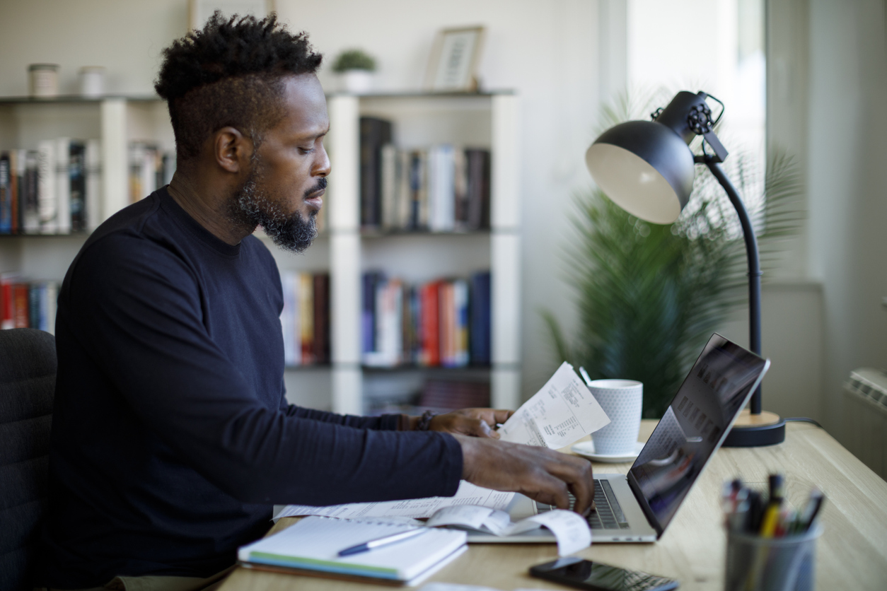 Man sitting in front of the computer doing his finances.