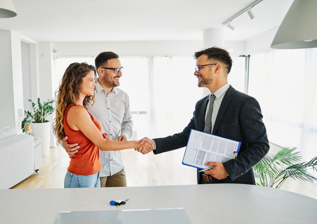 how much does a real estate agent make per sale agent shaking hands with couple