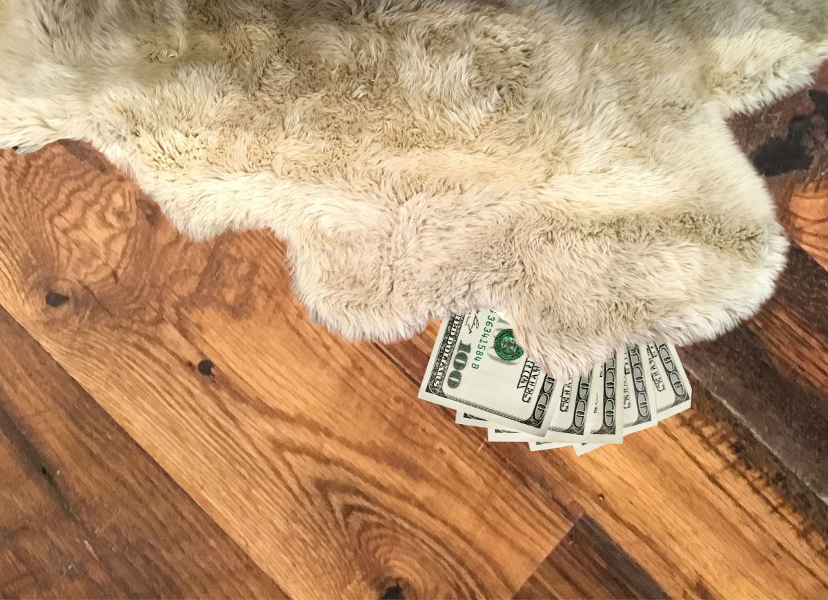 Getty Images Forbidden New Years Chores Hundred Dollar Bills under rug.jpg