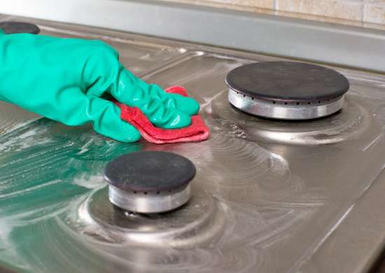fotosearch_bad_habits_ruining-appliances-gas-burners_cleaning_oven_with_soap