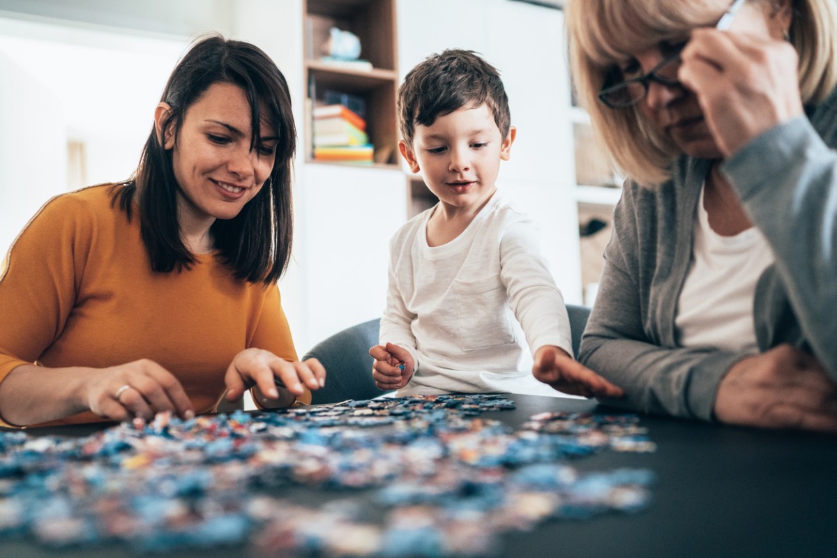 iStock-1218660491 how to glue a puzzle family doing jigsaw puzzle together