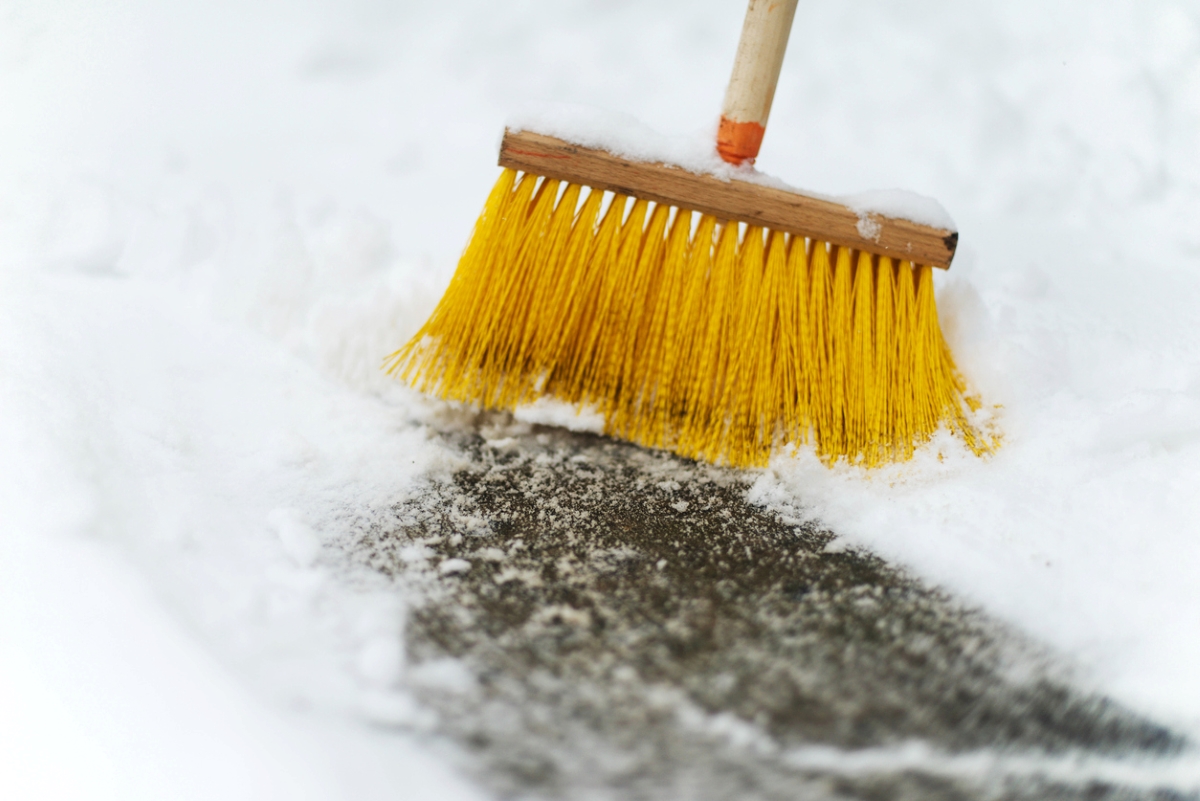 how to remove snow from a driveway without a shovel - clearing snow with broom