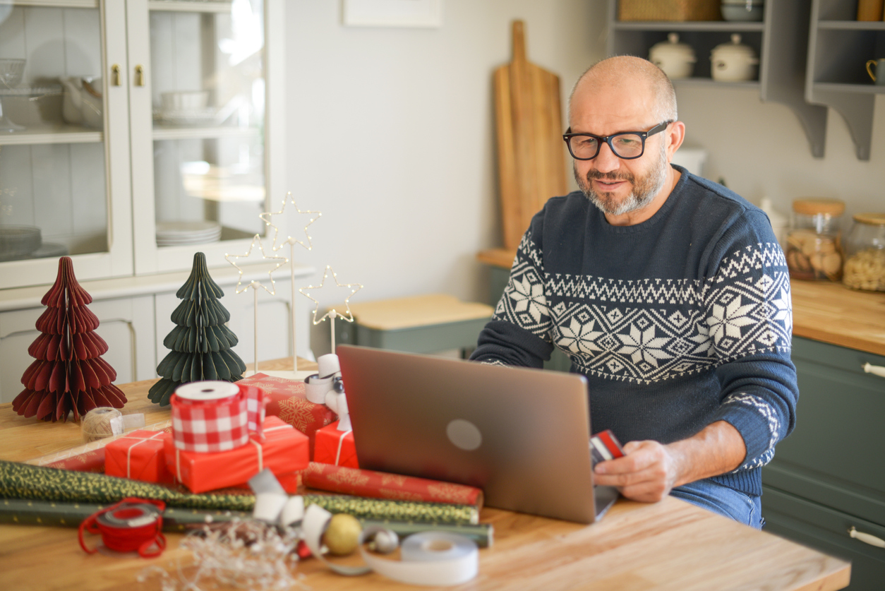 iStock-1351542190 holiday shopping man buying gifts online