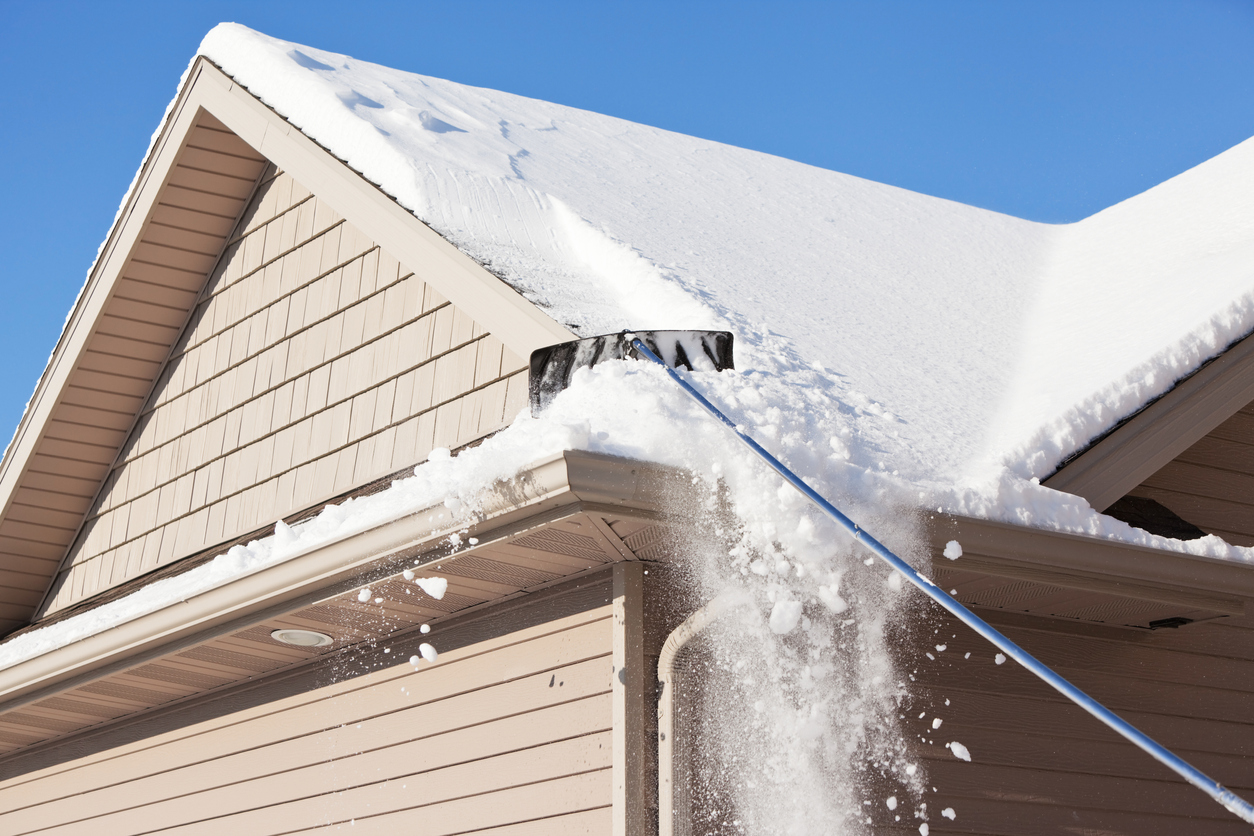 iStock-475197095 Winter Snow Water Reserves scraping snow off gutters.jpg