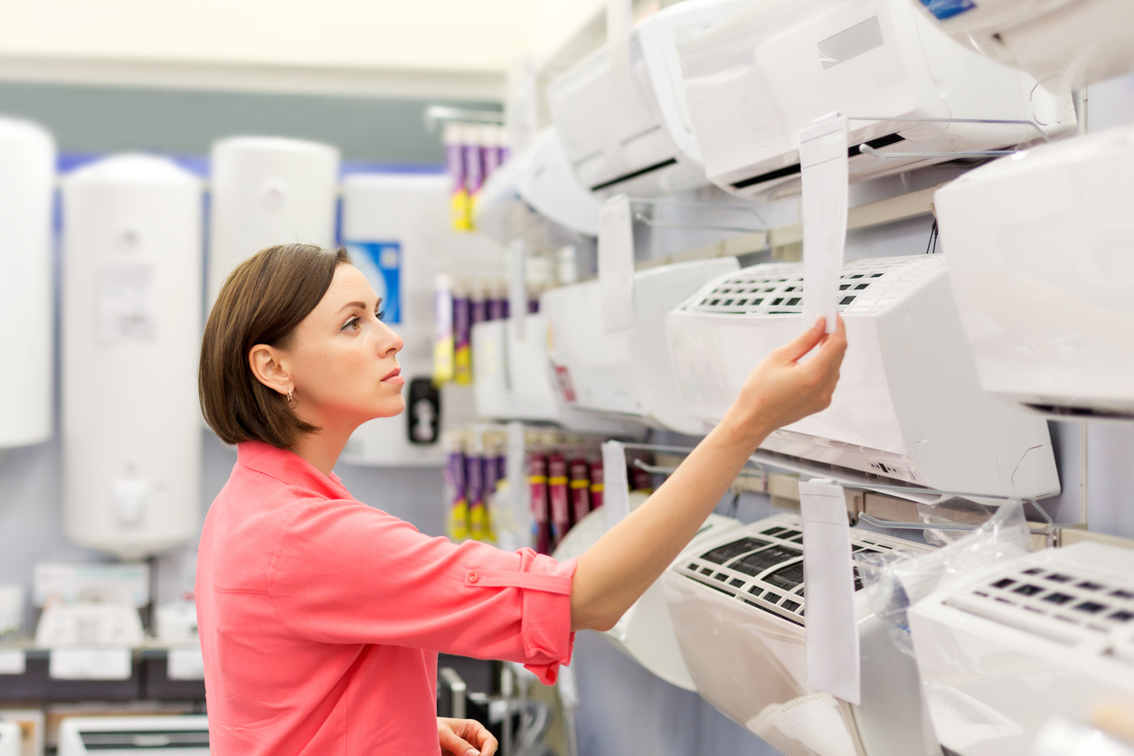Woman shopping for an air conditioner in an appliance store.
