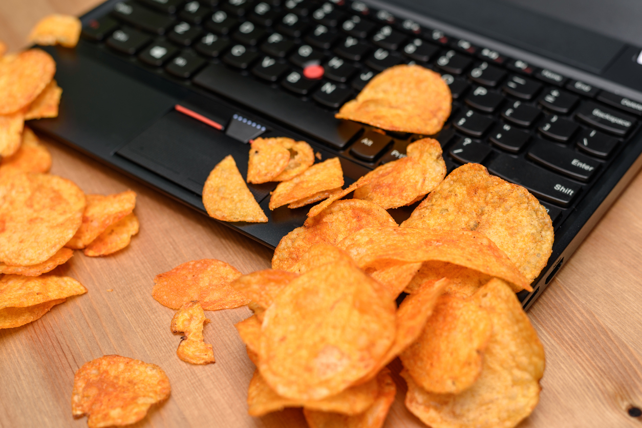 Closeup of potato chips on a laptop keyboard