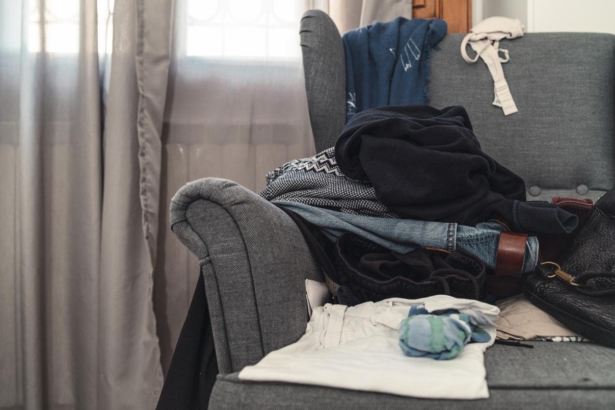 iStock-1067369568 ways to improve your life clothes piled up on armchair