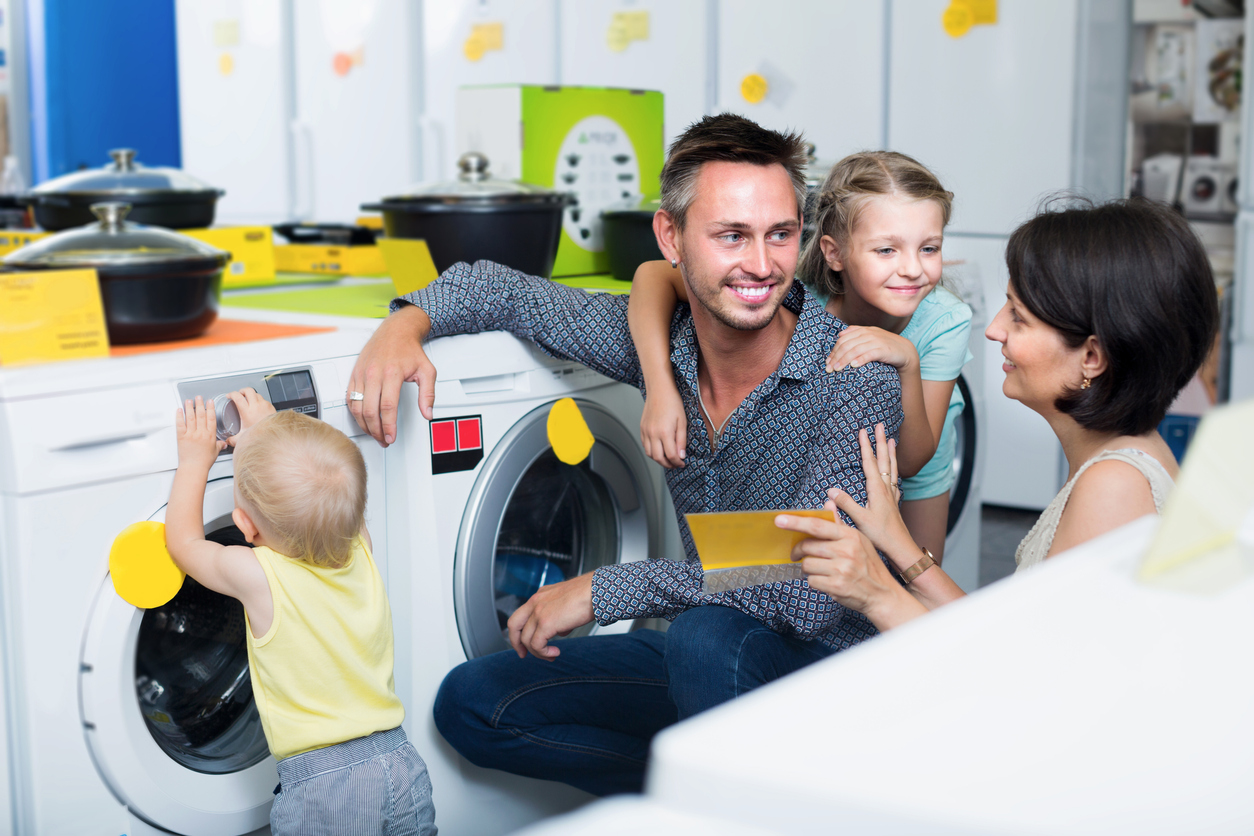 iStock-1070941210 home improvement tax holidays Smiling parents with kids shopping modern washer
